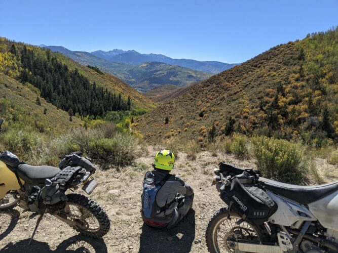 Dual sport motorcycles with view of mountains and valley surrounding Vail Colorado